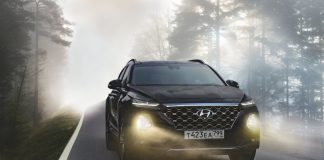 Stor bil kører igennem tåge med lys